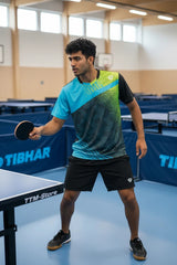 TTM-Store Tibhar PAINT polo shirt in turquoise and lime green with black sleeves, featuring a geometric pattern. Men's table tennis apparel.